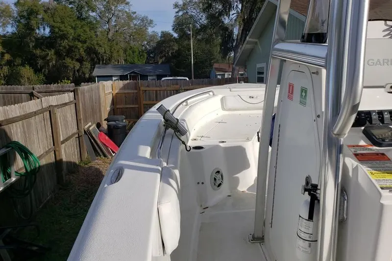 Slide: The Image of 2015 Sea Hunt Ultra 225 with Yamaha outboard motor, parked in a yard. - 3