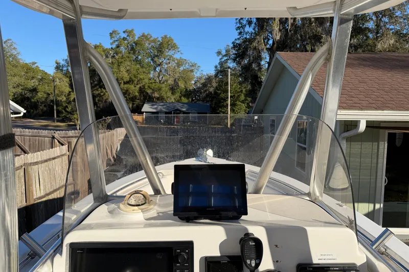 Slide: The Image of 2015 Sea Hunt Ultra 225 boat dashboard with navigation equipment and clear windshield. - 34