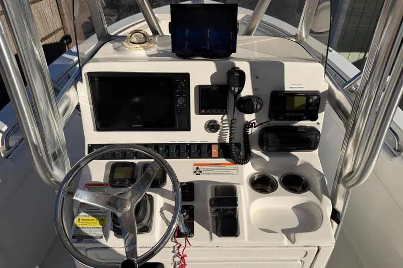 Slide: The Image of 2015 Sea Hunt Ultra 225 boat dashboard with steering wheel, navigation, and communication equipment. - 35