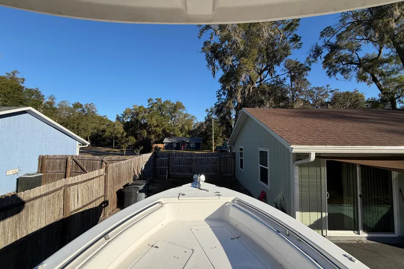 Slide: The Image of 2015 Sea Hunt Ultra 225 boat parked in a residential backyard. - 40