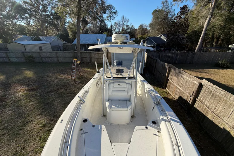 Slide: The Image of 2015 Sea Hunt Ultra 225 boat in a fenced yard, surrounded by trees and houses. - 46