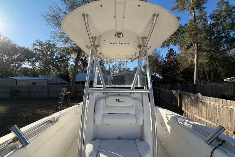 Slide: The Image of 2015 Sea Hunt Ultra 225 boat with T-top in a backyard setting. - 49