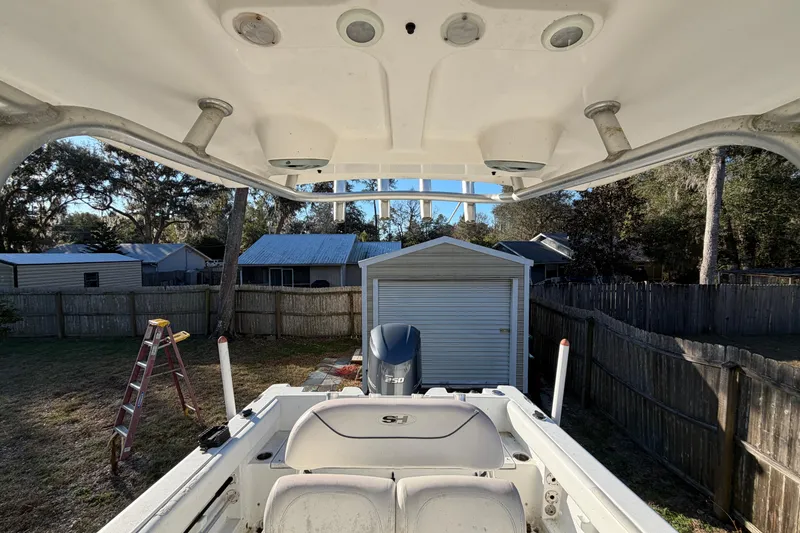 Slide: The Image of 2015 Sea Hunt Ultra 225 boat in backyard, featuring Yamaha engine and T-top. - 52