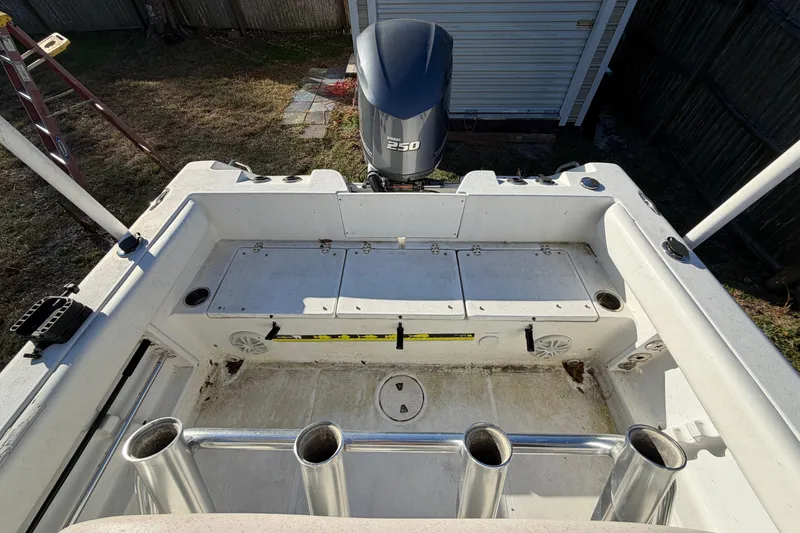 Slide: The Image of 2015 Sea Hunt Ultra 225 boat interior with Yamaha 250 engine, rod holders, and storage compartments. - 58