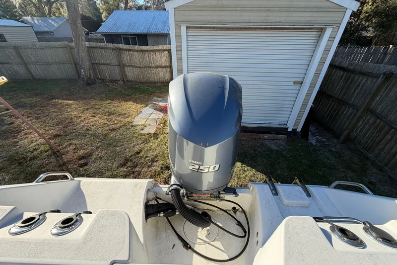 Slide: The Image of 2015 Sea Hunt Ultra 225 boat with Yamaha 250 engine in a backyard setting. - 59