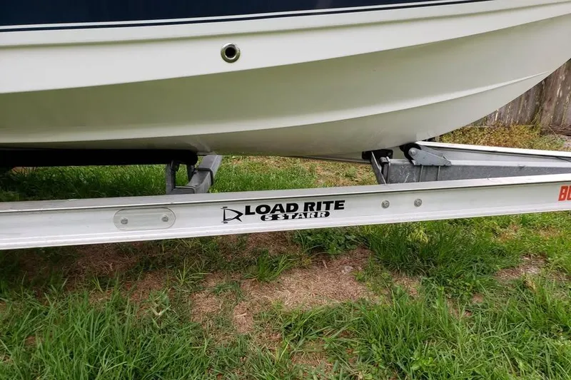 Slide: The Image of 2015 Sea Hunt Ultra 225 boat on trailer, parked outdoors with trees in background. - 9