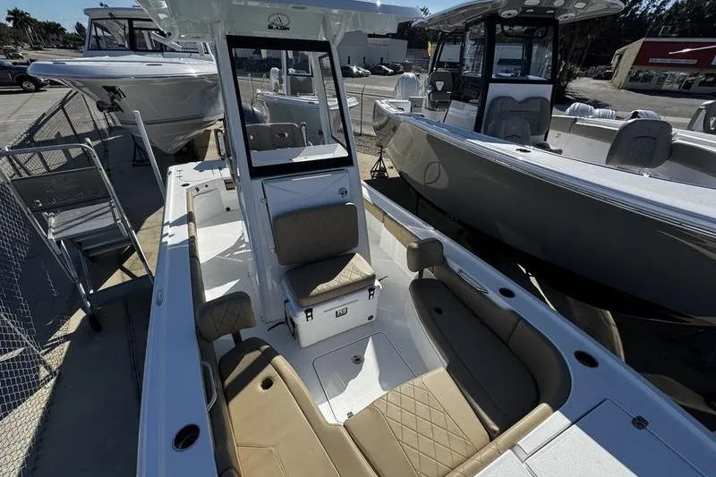 Slide: The Image of 2026 Blazer Bay 2400 boat with tan seating, docked in a marina. - 14