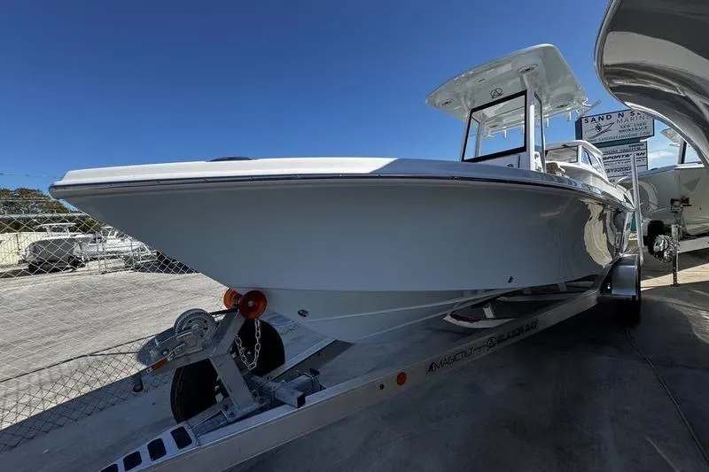 Slide: The Image of 2026 Blazer Bay 2400 boat on trailer, displayed outdoors under clear blue sky. - 2