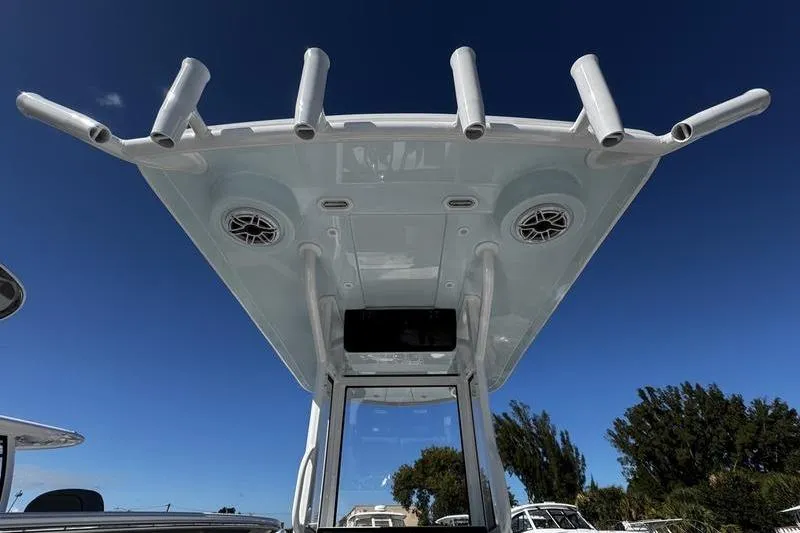 Slide: The Image of 2026 Blazer Bay 2400 boat top view with rod holders and speakers against clear blue sky. - 26