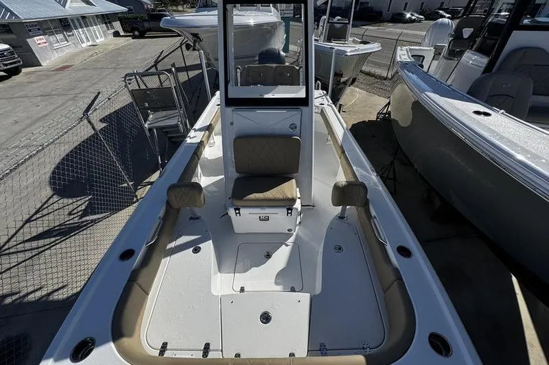 Slide: The Image of 2026 Blazer Bay 2400 boat interior with seating and console, docked at a marina. - 9