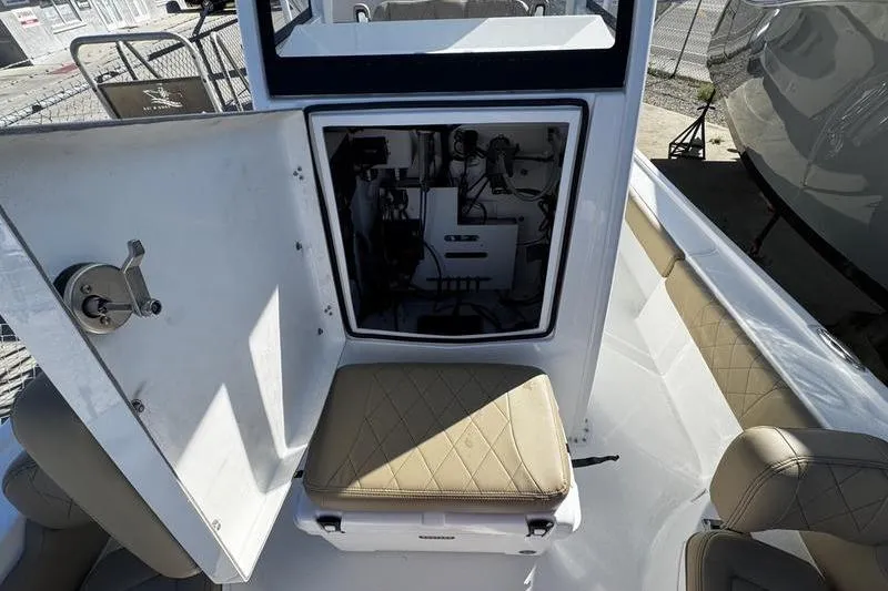 Slide: The Image of 2026 Blazer Bay 2400 boat interior with open storage compartment and cushioned seating. - 10