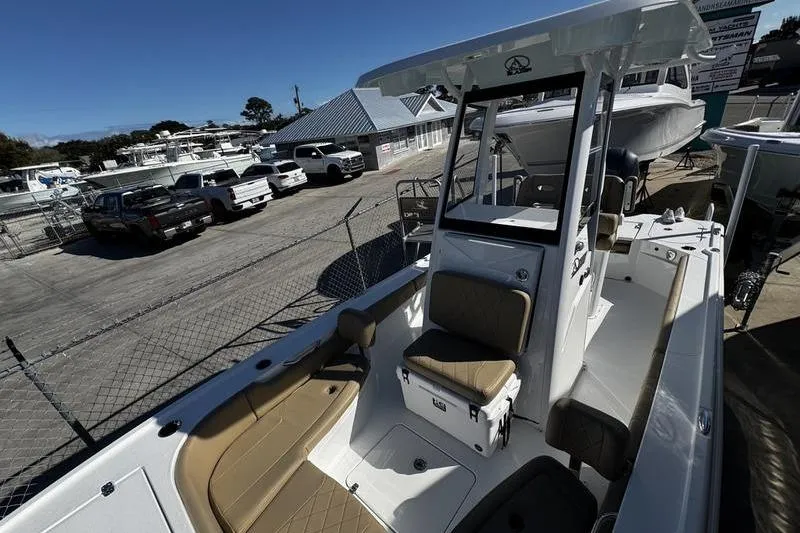 Slide: The Image of 2026 Blazer Bay 2400 boat with tan seating, parked in a marina. - 15