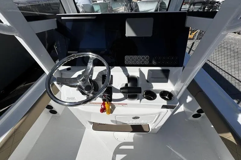Slide: The Image of 2026 Blazer Bay 2400 boat dashboard with steering wheel and controls. - 20
