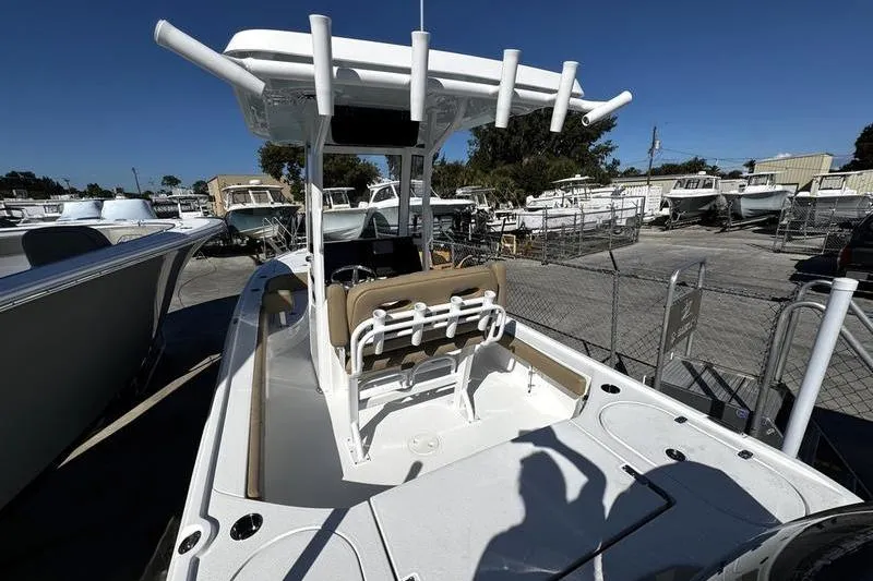 Slide: The Image of 2026 Blazer Bay 2400 boat with T-top and seating, displayed in a marina. - 5