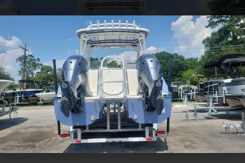 Slide: The Image of 2023 World Cat 280 DC-X boat with dual outboard motors, parked in a marina. - 1