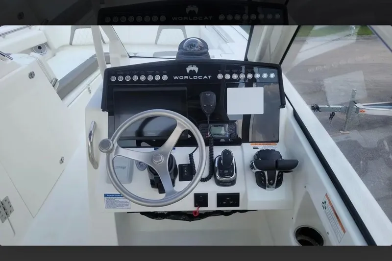 Slide: The Image of 2023 World Cat 280 DC-X boat helm with steering wheel and control panel. - 14