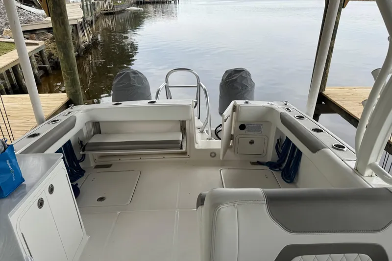 Slide: The Image of 2023 World Cat 280 DC-X boat interior with seating and storage, docked by calm water. - 25