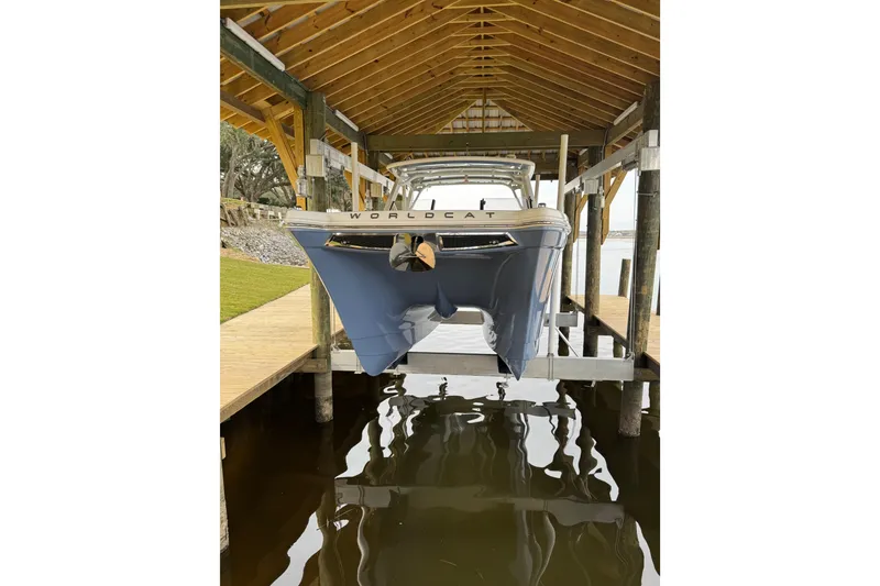 Slide: The Image of 2023 World Cat 280 DC-X boat docked under wooden shelter. - 28