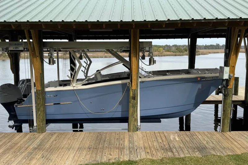 Slide: The Image of 2023 World Cat 280 DC-X boat docked under a covered structure by the water. - 29