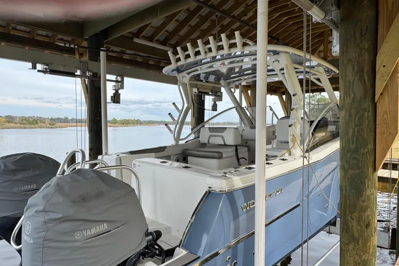 Slide: The Image of 2023 World Cat 280 DC-X boat docked with Yamaha engines, under a wooden shelter. - 31