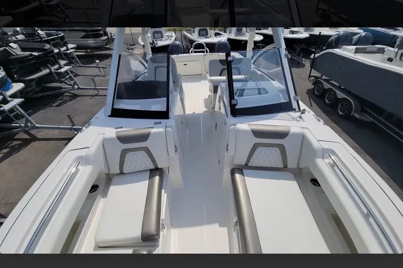 Slide: The Image of 2023 World Cat 280 DC-X boat interior with seating and windshield, docked outdoors. - 4