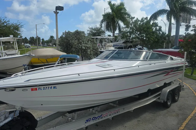 Slide: The Image of 2004 Formula 292 FASTech boat on trailer, parked outdoors with palm trees. - 1