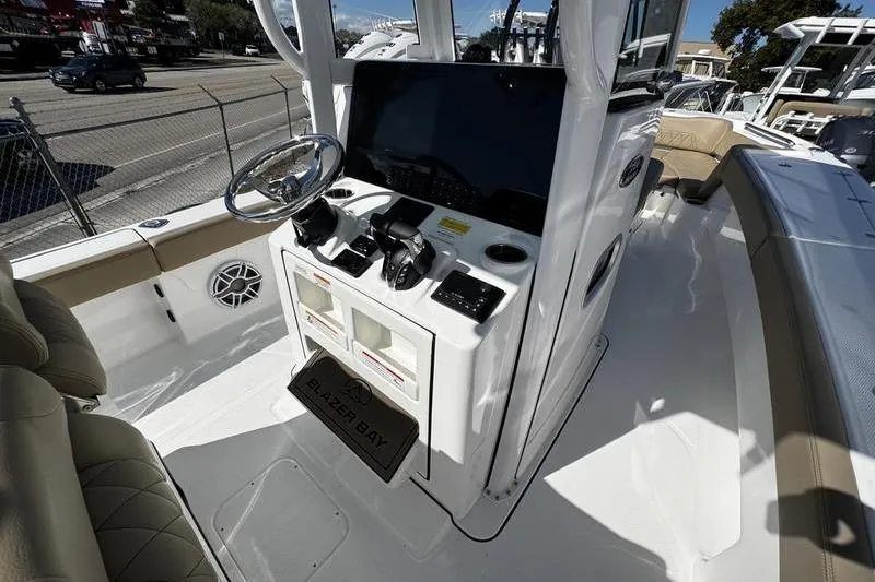 Slide: The Image of 2026 Blazer Bay Makaira 2800 boat cockpit with steering wheel and control panel. - 13