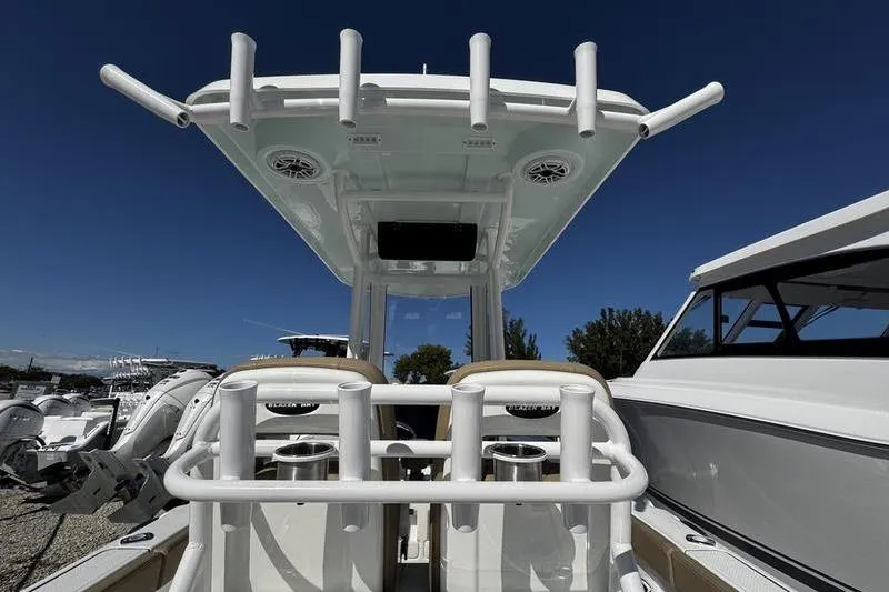 Slide: The Image of 2026 Blazer Bay Makaira 2800 boat with rod holders and T-top under clear blue sky. - 19