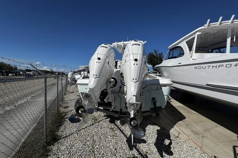 Slide: The Image of 2026 Blazer Bay Makaira 2800 with dual outboard engines, parked beside a road. - 24