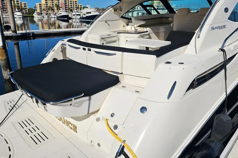 Slide: The Image of 2015 Sea Ray 410 Sundancer yacht docked at marina, showcasing sleek design and spacious deck. - 14