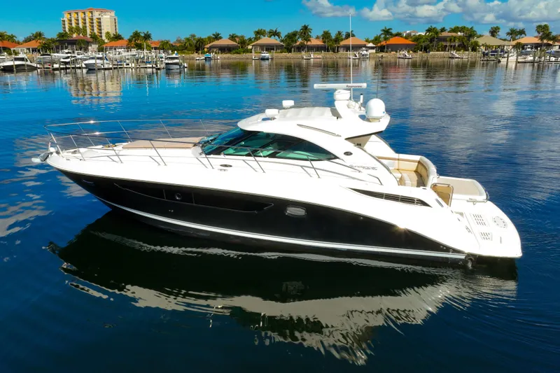 Slide: The Image of 2015 Sea Ray 410 Sundancer yacht on calm water, marina background. - 2