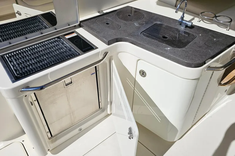 Slide: The Image of Outdoor kitchen area on a 2015 Sea Ray 410 Sundancer yacht, featuring a sink and grill. - 23