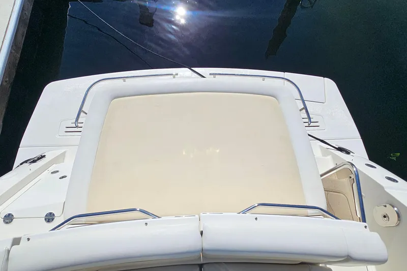 Slide: The Image of 2015 Sea Ray 410 Sundancer boat deck with sun pad, docked on calm water. - 26