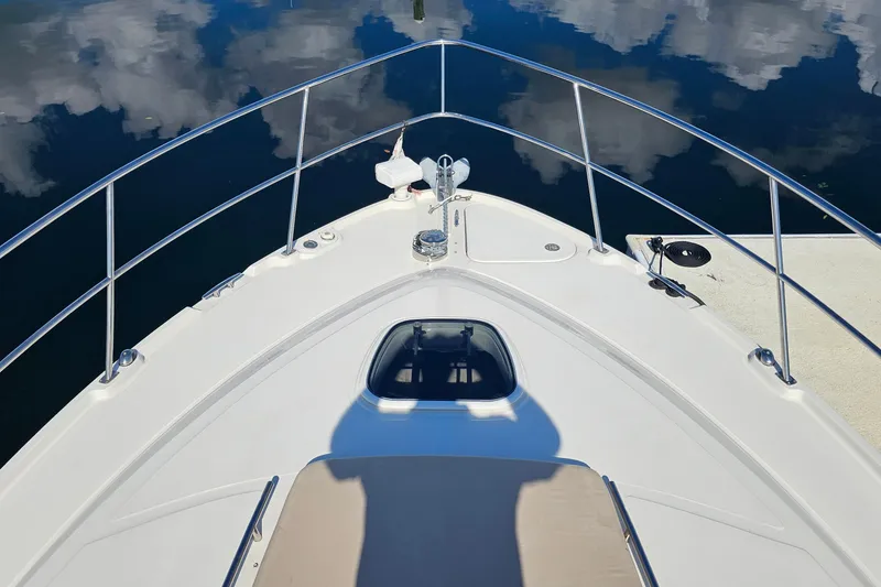 Slide: The Image of Bow view of 2015 Sea Ray 410 Sundancer reflecting on calm water. - 27