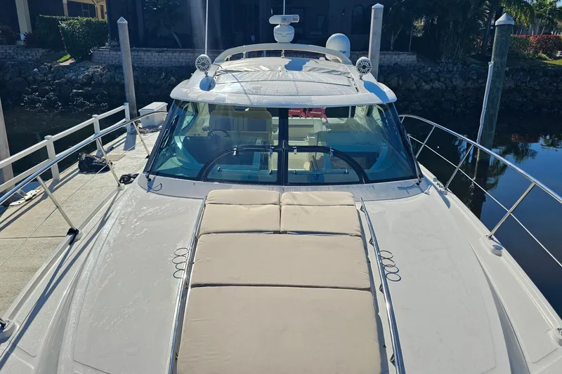 Slide: The Image of 2015 Sea Ray 410 Sundancer yacht docked, featuring spacious sunbathing area and sleek design. - 28