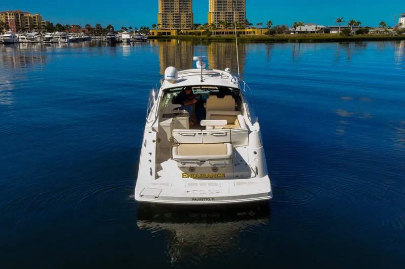 Slide: The Image of 2015 Sea Ray 410 Sundancer yacht on calm water near marina. - 3
