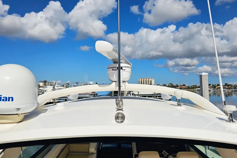 Slide: The Image of 2015 Sea Ray 410 Sundancer yacht with radar, docked under a blue sky. - 31