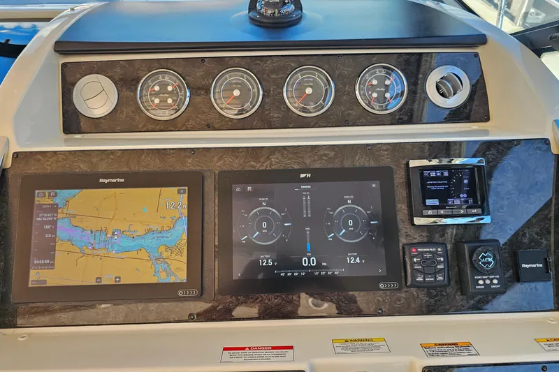 Slide: The Image of Dashboard of a 2015 Sea Ray 410 Sundancer with navigation and control displays. - 34