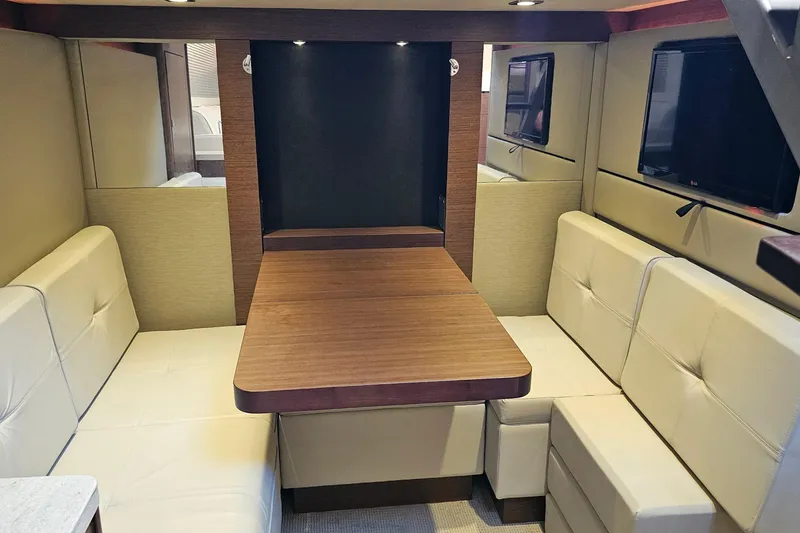 Slide: The Image of Luxurious interior of 2015 Sea Ray 410 Sundancer yacht with plush seating and wooden table. - 41
