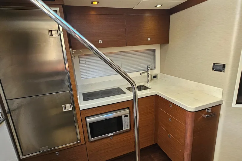 Slide: The Image of Modern kitchen in 2015 Sea Ray 410 Sundancer yacht with stainless appliances and wood cabinetry. - 43