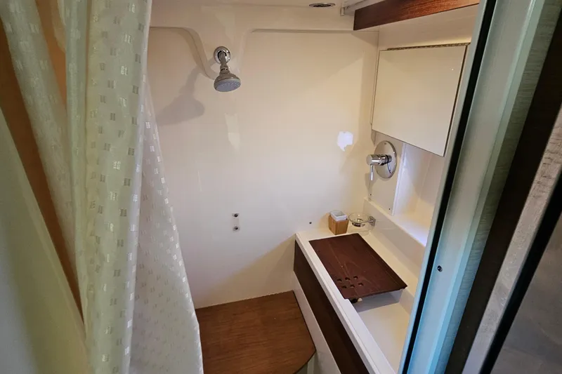 Slide: The Image of 2015 Sea Ray 410 Sundancer bathroom with shower, wooden accents, and curtain. - 44