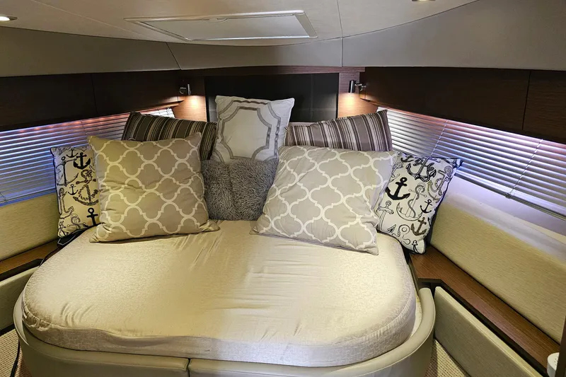 Slide: The Image of Luxurious cabin interior of 2015 Sea Ray 410 Sundancer with plush pillows and ambient lighting. - 49