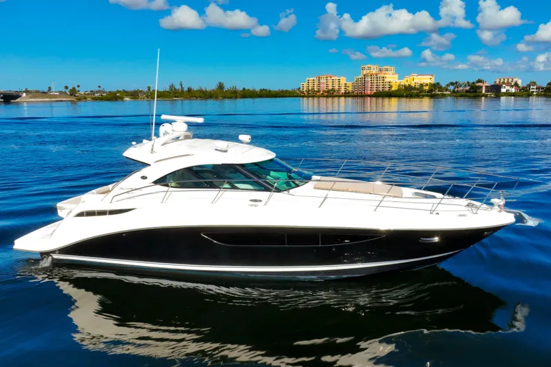 Slide: The Image of 2015 Sea Ray 410 Sundancer yacht cruising on a sunny day with scenic waterfront backdrop. - 8
