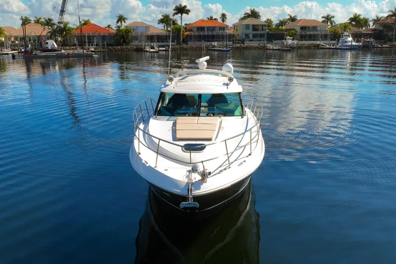 Slide: The Image of 2015 Sea Ray 410 Sundancer yacht on calm water near waterfront homes. - 9