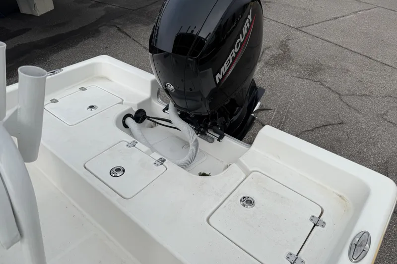 Slide: The Image of 2022 Clearwater 2100 Baystar boat with Mercury outboard motor, white deck, and storage compartments. - 6