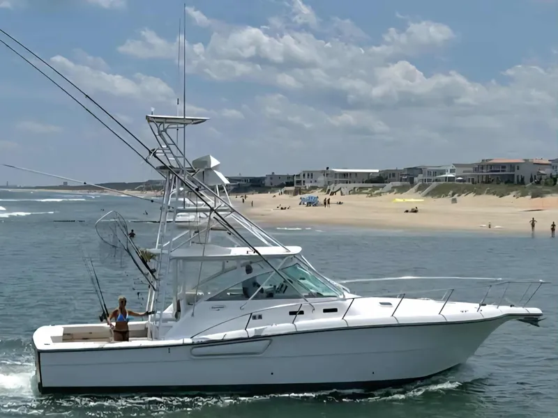 Slide: The Image of 2002 Rampage 38 Express boat near beach backdrop. - 0