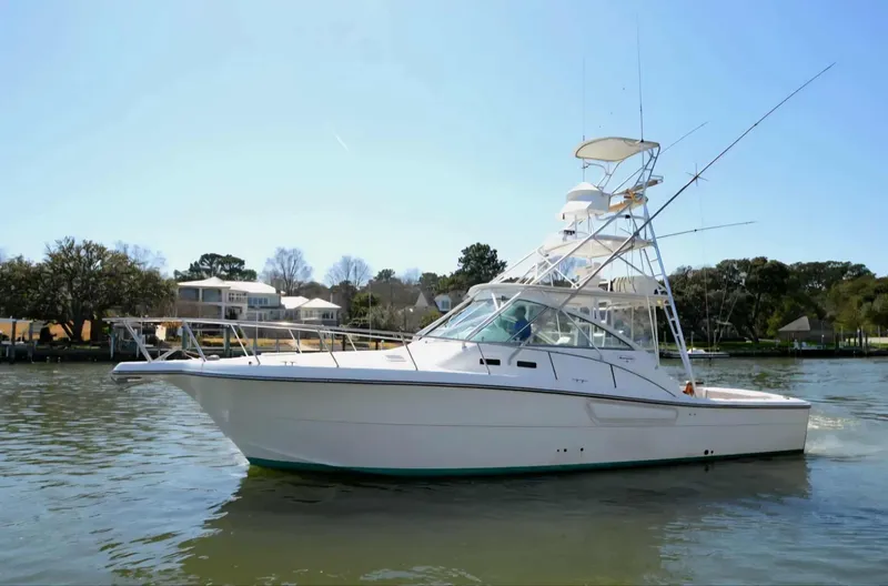 Slide: The Image of 2002 Rampage 38 Express boat on calm water. - 2