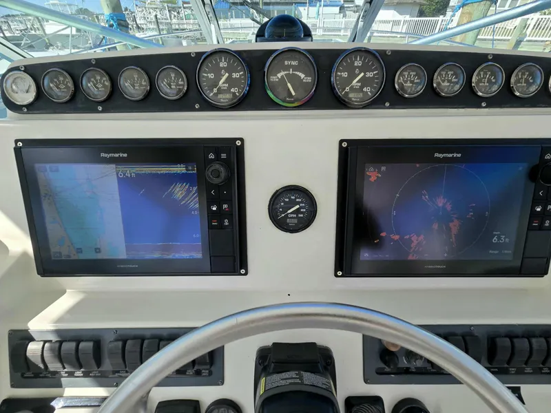 Slide: The Image of 2002 Rampage 38 Express helm with Raymarine displays and gauges. - 27