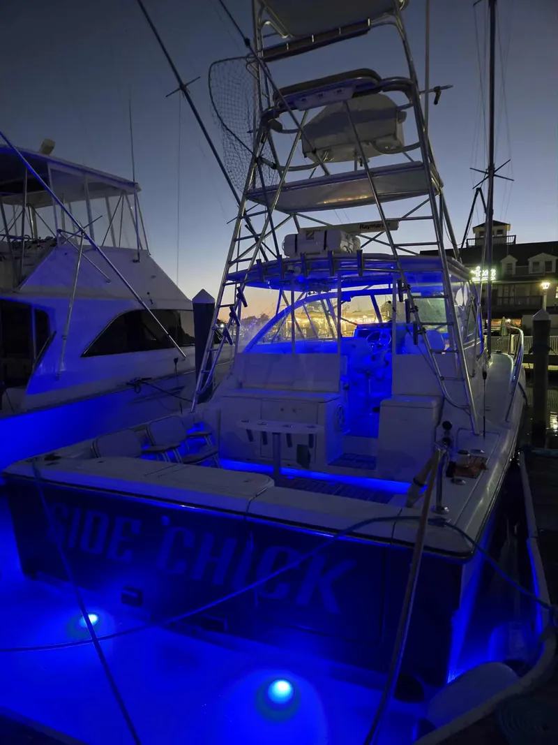 Slide: The Image of 2002 Rampage 38 Express boat with blue lighting at the dock. - 5