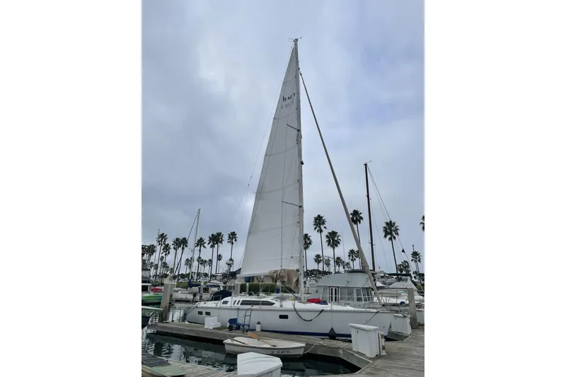 Slide: The Image of Sailboat docked at marina, Hunter Legend 40, 1994 model, with tall mast and palm trees. - 10